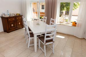 een witte tafel en stoelen in een keuken met een raam bij Landhaus Pohlhof in Keulen