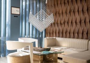a living room with a couch and a chandelier at Hotel Perla Suite Santa Marta in Santa Marta