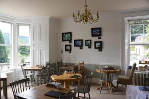 een restaurant met tafels en stoelen en een kroonluchter bij Tigh Na Cloich in Pitlochry