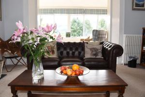 a living room with a couch and a table with a bowl of fruit at Tigh Na Cloich in Pitlochry