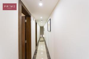un largo pasillo con paredes blancas y puertas de madera en Prime Select Porto New Cairo en El Cairo
