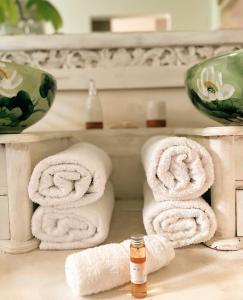un mucchio di asciugamani seduti su un bancone del bagno di Chambres d'hôtes & spa Le Jardin de Ravintsara a Ravine des Cabris