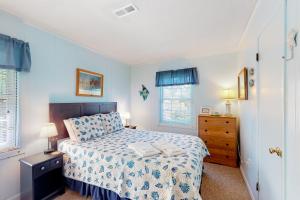 ein Schlafzimmer mit einem Bett, einer Kommode und zwei Fenstern in der Unterkunft Blue Dolphin 054 in Avon