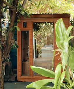 Chambres d'hôtes & spa Le Jardin de Ravintsara في Ravine des Cabris: باب دخول خشبي إلى منزل به شجرة