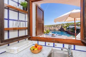 a kitchen with a sink and a view of the ocean at Vacaciones en Cala Morell in Cala Morell