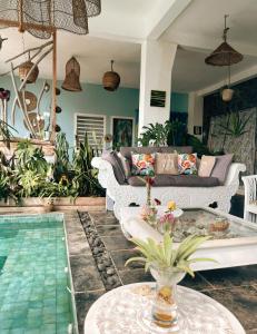 a living room with a couch and a pool at Chambres d'hôtes & spa Le Jardin de Ravintsara in Ravine des Cabris