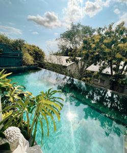 una piscina de agua azul en un patio en Chambres d'hôtes & spa Le Jardin de Ravintsara, en Ravine des Cabris