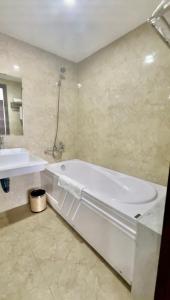 a bathroom with a white tub and a sink at Minh Anh Hotel & Apartment in Hai Phong