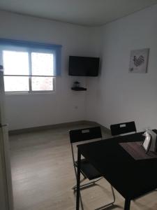 a room with a table and two chairs and a television at Vivienda Vacacional Las Toscas in Las Toscas