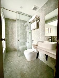 uma casa de banho com um lavatório, um WC e um chuveiro em Minh Anh Hotel & Apartment em Haiphong