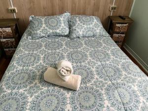 Una cama con toalla y almohadas. en Departamentos Patagonia en Puerto Natales