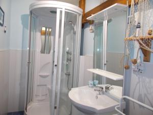 a bathroom with a shower and a sink and a toilet at La Ferme de Genarville in Bouville
