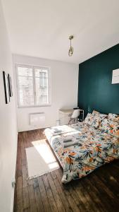 een slaapkamer met een bed en een groene muur bij Balcon du Champ de Mars - Wifi / Parking in Angoulême