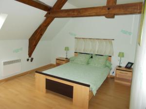 1 dormitorio con cama grande y vigas de madera en La Ferme de Genarville en Bouville