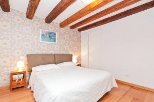 Schlafzimmer mit einem weißen Bett und Holzboden in der Unterkunft Ca' Giardini in Venedig