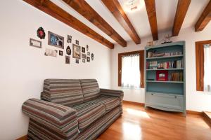 uma sala de estar com um sofá e uma estante de livros em Ca' Giardini em Veneza
