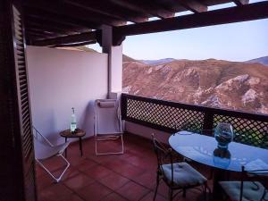 a balcony with a table and chairs and a mountain view at Apartamento en el corazon de las Alpujarras in Carataunas