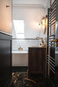 a bathroom with a sink and a bath tub at The West End Loft - 5* Retreat - Private Parking! in Glasgow