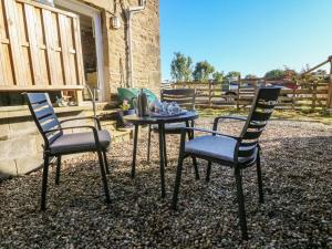two chairs and a table in front of a house at Moor Cottage in Carnforth