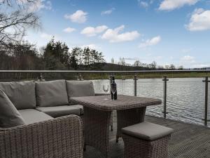 Golf View في أبوين: فناء مع أريكة وطاولة مع زجاجة من النبيذ