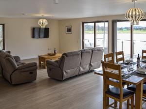 a living room with a couch and a table and chairs at Golf View in Aboyne