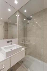 bagno bianco con lavandino e doccia di Casa Boma Lisboa - Design & Spacious Apartment With Balcony - Alvalade II a Lisbona