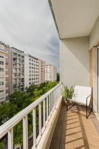 un balcón con un banco blanco en un edificio en Casa Boma Lisboa - Design & Spacious Apartment With Balcony - Alvalade II en Lisboa