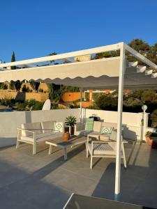 a patio with a white pergola and tables and chairs at Penthouse with stunning views in Benahavís in Benahavís