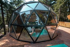 a glass igloo house with a pool on a deck at Seri in Keda