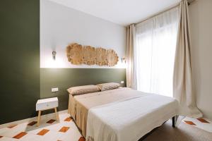 sypialnia z łóżkiem i oknem w obiekcie Dimore Dalle Zie w Alberobello