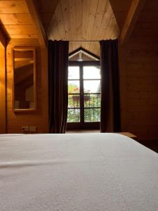 a bedroom with a white bed and a window at Locanda Bocchetto Sessera in Bielmonte