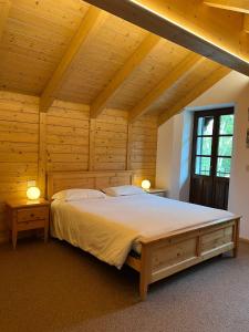 a bedroom with a large bed in a wooden ceiling at Locanda Bocchetto Sessera in Bielmonte