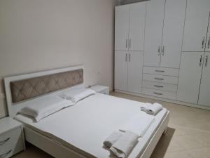 Un dormitorio blanco con una cama con toallas. en Seascape Apartments Vlore, en Vlorë