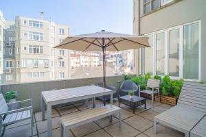 a patio with a table and chairs and an umbrella at Feel Porto Downtown Apartments & Studios in Porto