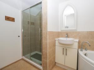 a bathroom with a shower and a sink and a mirror at Wesley House in Shepton Mallet