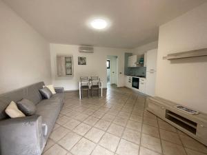 a large living room with a couch and a kitchen at Alloggio incantevole Costa Smeralda in Porto Pozzo
