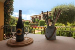 a bottle of wine and two glasses on a table at Alloggio incantevole Costa Smeralda in Porto Pozzo