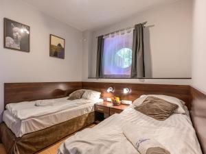 a room with two beds and a desk and a window at VisitZakopane - Dubaj Apartment in Zakopane