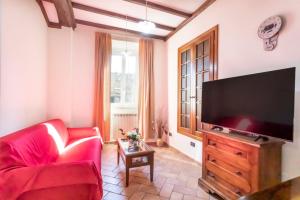 a living room with a red couch and a flat screen tv at La Casa di Lalla in Sutri