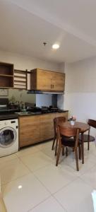 cocina con mesa y lavadora en Timurbay Residence with Seaview 6pax 2Bedrooms Level 9 Kuantan, en Kampung Sungai Karang