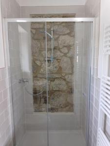 a shower in a bathroom with a stone wall at Minicasa nella fattoria in Atessa