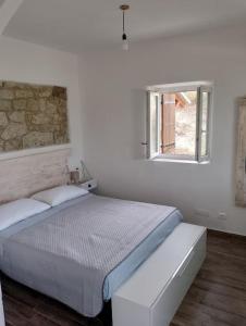 a white bedroom with a bed and a window at Minicasa nella fattoria in Atessa