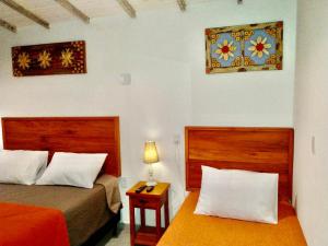 a bedroom with two beds and a table with a lamp at Casa Temporada Tiradentes in Tiradentes