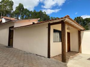 a small white house with a roof at Casa Temporada Tiradentes in Tiradentes