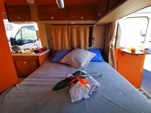 Rúm í herbergi á Rent a BlueClassics 's Campervan combi J9 en Algarve au Portugal