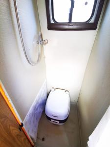 a small bathroom with a shower and a toilet at Rent a BlueClassics 's Campervan combi J9 en Algarve au Portugal in Portimão