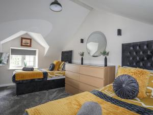 1 Schlafzimmer mit 2 Betten und einem Spiegel in der Unterkunft Lleiniog Cottage in Beaumaris