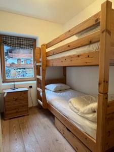 a bedroom with two bunk beds and a window at Casa Alfredino in Rocca Pietore