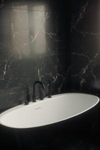 un lavandino bianco in un bagno con parete nera di The Hikers House a Newcastle