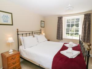 a bedroom with a bed with two towels on it at South Wing Cottage in Yelverton